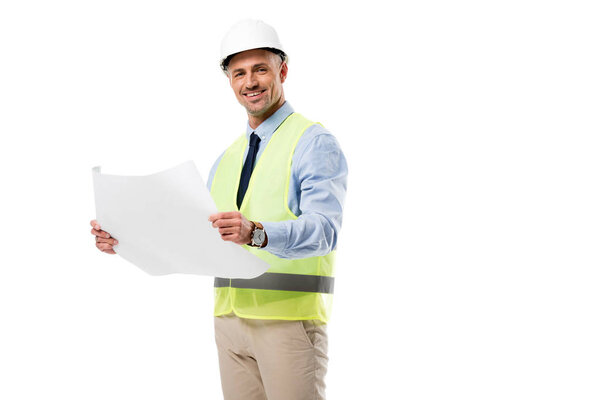 handsome engineer in helmet looking at camera and holding blueprint isolated on white