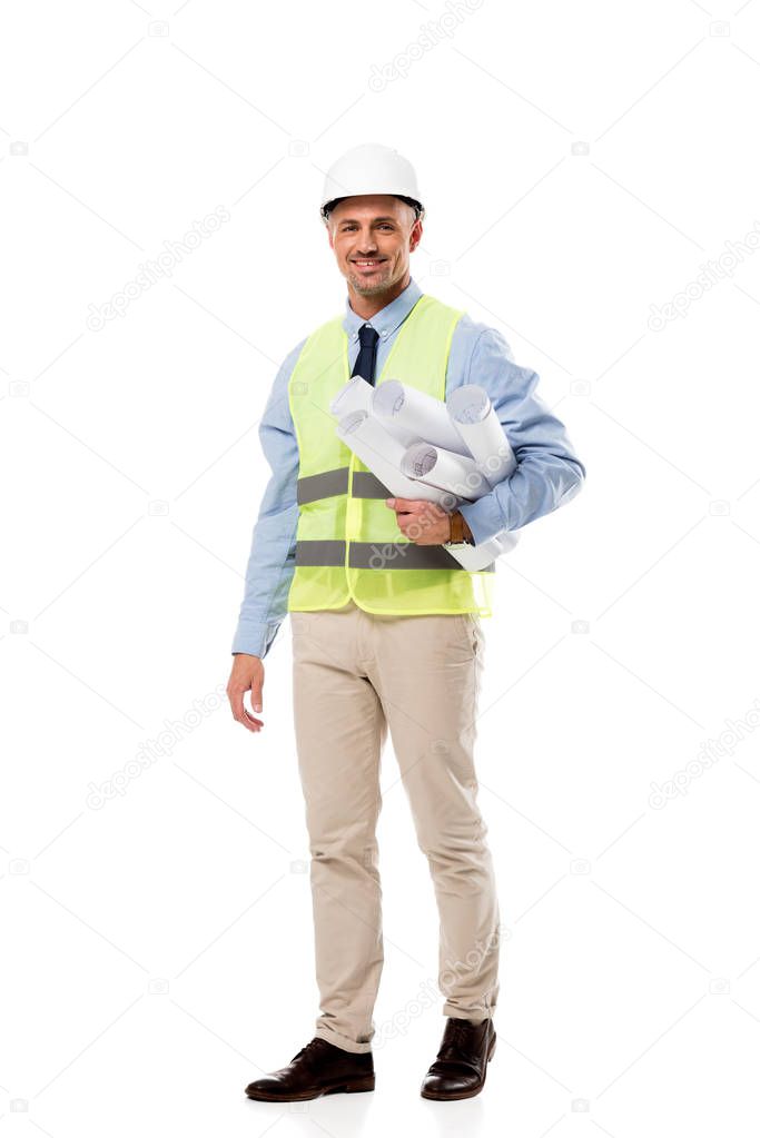 handsome engineer looking at camera and holding blueprints isolated on white