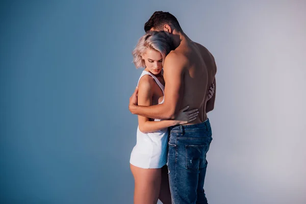 Young Heterosexual Couple Embracing Dark Blue Background — Stock Photo, Image