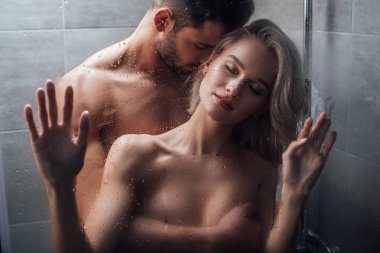 handsome man passionately embracing attractive woman in shower  clipart