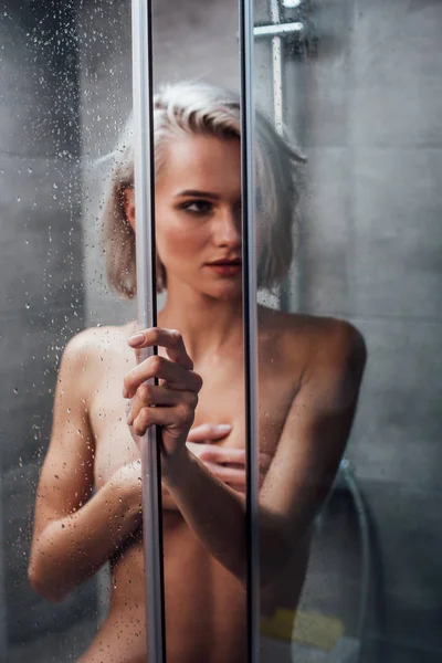 裸体的感性的女人拿着淋浴门 把目光移开 在浴室摆姿势 — 图库照片