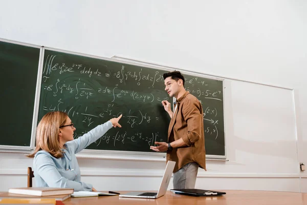 Profesor Wanita Menunjuk Pada Papan Tulis Dengan Persamaan Selama Pelajaran — Stok Foto