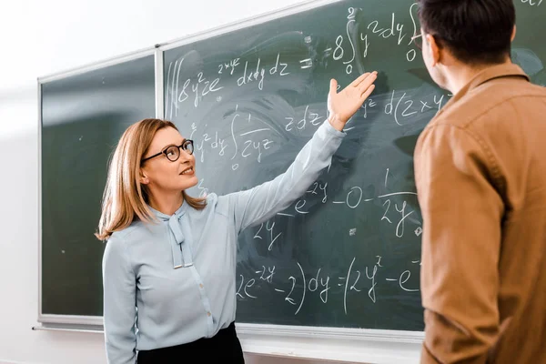 Ženské Profesor Ukazuje Rovnice Učebně — Stock fotografie