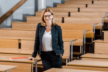 gülümseyen ve sınıf kamera bakıyor güzel kadın üniversite profesörü