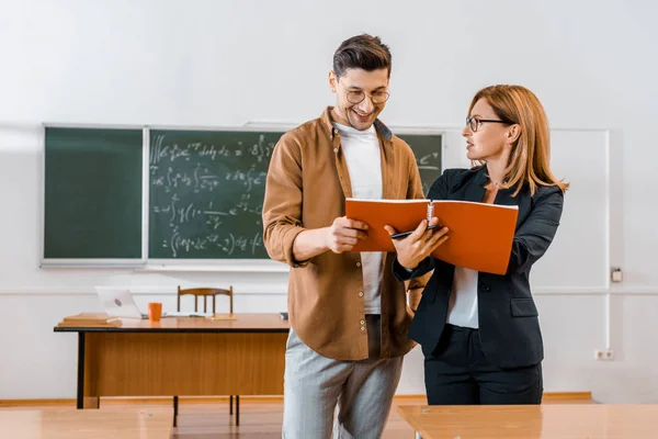 Vrouwelijke Leraar Helpen Mannelijke Student Met Toewijzing Tijdens Les Klas — Stockfoto