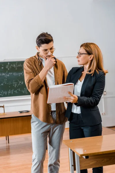 Professora Ajudando Estudante Masculino Pensativo Com Atribuição Durante Lição Sala — Fotografia de Stock