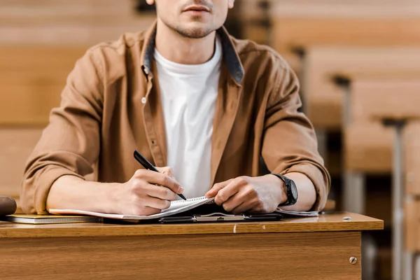 Vista Recortada Del Estudiante Masculino Sentado Escritorio Escribiendo Cuaderno Durante —  Fotos de Stock
