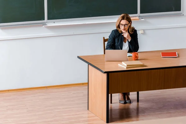 Profesor Perempuan Berkacamata Duduk Meja Dan Menggunakan Laptop Kelas — Stok Foto