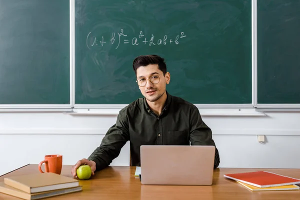 Male Teacher Glasses Sitting Computer Desk Holding Apple Looking Camera — Stock Photo, Image