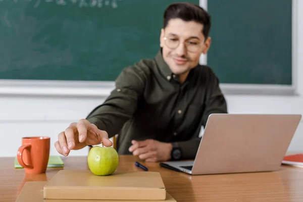 Male Teacher Glasses Sitting Computer Desk Reaching Apple Classroom — Stock Photo, Image
