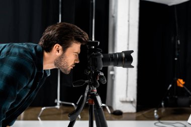 genç fotoğrafçı profesyonel fotoğraf makinesi Studio ile çalışma yan görünüm  