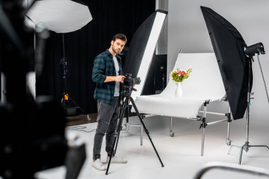 fotoğraf makinesi ile çalışma ve ekipman fotoğraf stüdyosunda aydınlatma yakışıklı genç fotoğrafçı 
