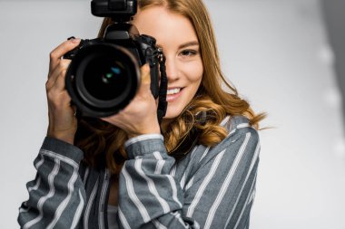 stüdyoda fotoğraf makinesi kullanan güzel gülümseyen kız