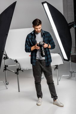 yakışıklı profesyonel genç fotoğrafçı fotoğraf makinesi fotoğraf Studio'yu kullanarak görünümünü tam uzunlukta 
