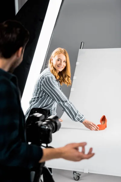 Cropped Shot Male Photographer Looking Colleague Arranging Shoe Studio — Free Stock Photo