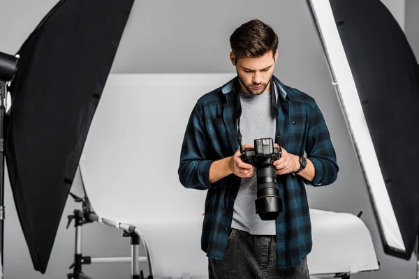 Jovem Fotógrafo Profissional Bonito Usando Câmera Fotos Estúdio — Fotografia de Stock