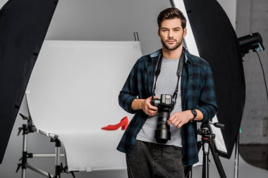 yakışıklı profesyonel genç fotoğrafçı Studio kamera bakıyor 