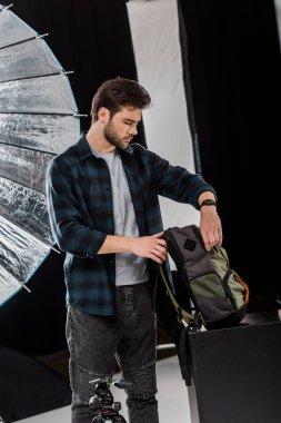 yakışıklı genç fotoğrafçı profesyonel fotoğraf ekipmanları sırt çantasında ambalaj 