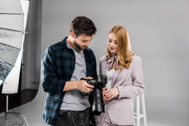 yakışıklı genç fotoğrafçı ve fotoğraf makinesi birlikte Studio'yu kullanarak güzel gülümseyen kız