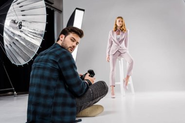 oturma ve stüdyoda güzel kadın model poz ise kameraya bakarak fotoğrafçı 