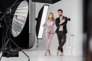 genç fotoğrafçı kamera ve güzel kadın model ayakta photo studio birlikte