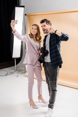 mutlu genç fotoğrafçı ve güzel gülümseyen model alarak selfie ile smartphone fotoğraf Studio 