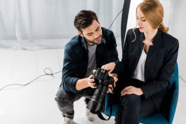genç fotoğrafçı ve fotoğraf makinesi birlikte studio kullanarak modeli gülümseyen 