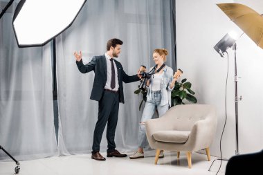 kahve tutarak ve fotoğrafçı Studio ile konuşurken mutlu işadamı
