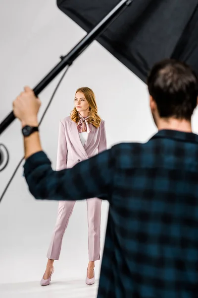 Back View Photographer Working Lighting Equipment While Female Model Posing — Free Stock Photo