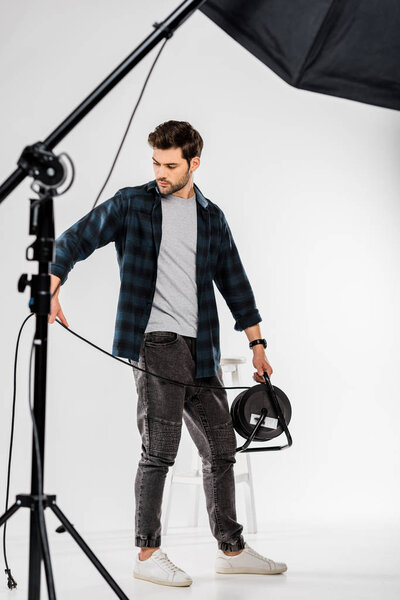 young photographer working with photo equipment in professional studio  