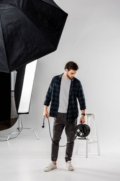 young man working with photo equipment in professional studio  