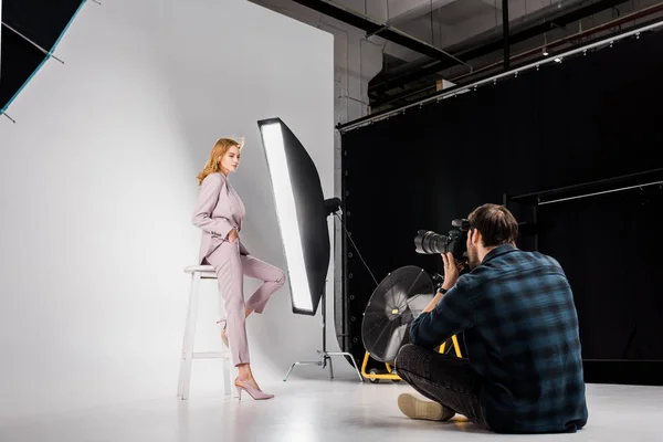 Young Photographer Sitting Photographing Attractive Stylish Female Model Studio — Free Stock Photo
