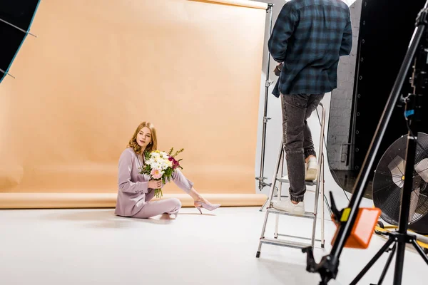 Przycięte Zdjęcie Fotograf Stojąc Drabince Piękna Dziewczyna Pozuje Bukietem Kwiatów — Darmowe zdjęcie stockowe