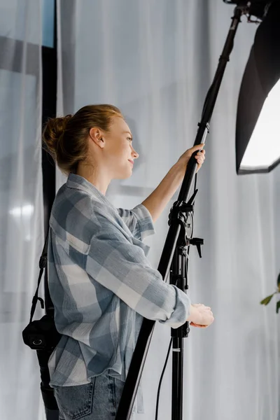 Hermosa Joven Fotógrafo Sonriente Trabajando Con Equipos Iluminación Estudio — Foto de stock gratuita