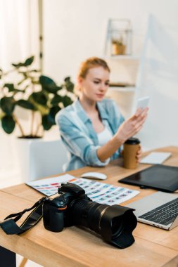 fotoğraf makinesi ve arkasında smartphone kullanan genç kadın görmek