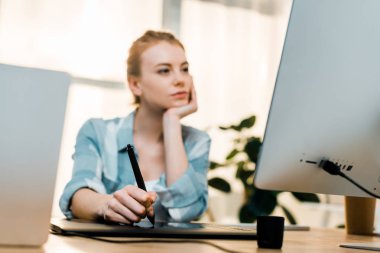 Masaüstü bilgisayar kullanarak ve ofiste tablet çizim genç retoucher yakından görmek 