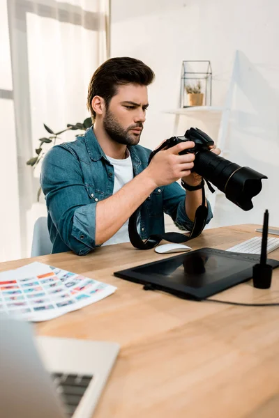Handsome Young Photographer Using Camera Workplace — Free Stock Photo