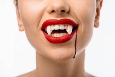 Kırmızı dudaklar, vampir dişleri ve üzerinde beyaz izole yüzündeki kan ile kızın kırpılmış atış
