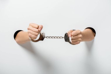 Kızın beyaz deliklerden elele kelepçeli kırpılmış görüntü