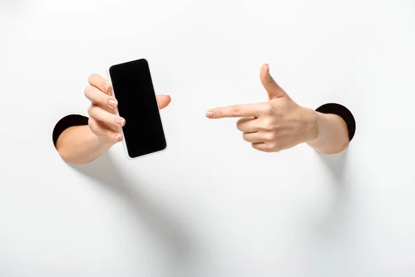 Cropped Image Woman Pointing Smartphone Blank Screen Holes White — Stock Photo, Image