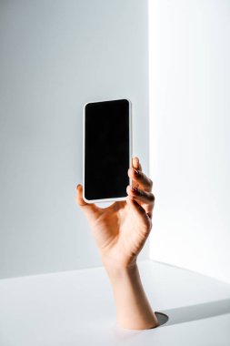 boş ekran ile akıllı telefon üzerinde beyaz delikten elinde tutan kadın kırpılmış görüntü