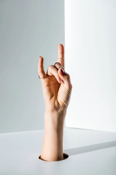 Wykadrowanego Obrazu Kobieta Pokazując Rock Znak Przez Otwór Białym — Zdjęcie stockowe