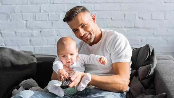 Smiling Father Baby Daughter Sitting Couch Holding Remote Controller Watching — Stock Photo, Image