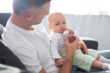Baba evde şişeden bebek kızının beslenme 