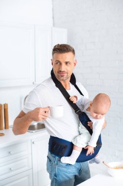 baba holding bebek kız bebek taşıyıcı ve içkiyle Kupası 
