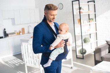 yakışıklı işadamı holding bebek kızı güneş ışığı ile odada