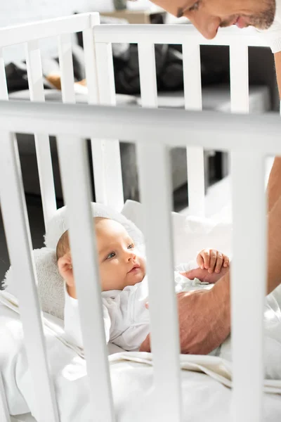 Vista Recortada Papá Feliz Poniendo Bebé Alegre Cuna Bebé — Foto de stock gratis