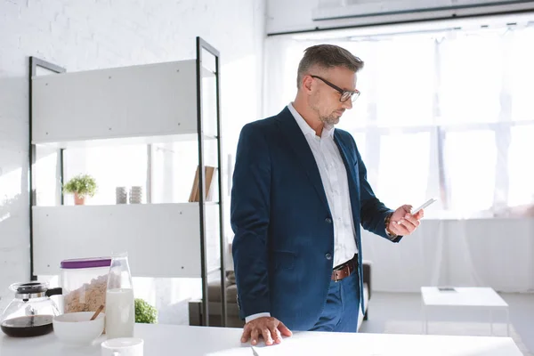 Pensive Businessman Glasses Looking Smartphone — Free Stock Photo