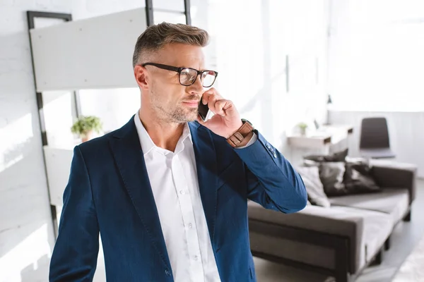 Schöner Geschäftsmann Mit Brille Der Wohnzimmer Mit Dem Smartphone Spricht — Stockfoto