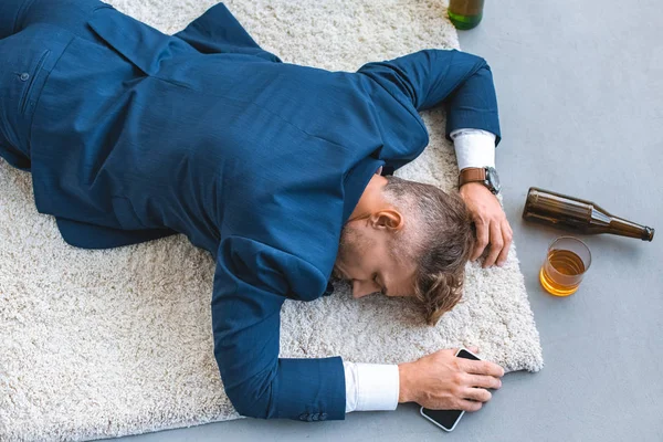 Bovenaanzicht Van Dronken Zakenman Liggend Een Tapijt Met Smartphone Hand — Stockfoto